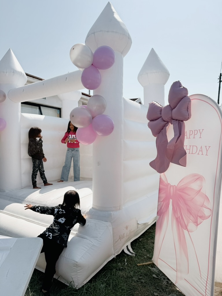 White jumping castle with slide and birthday board