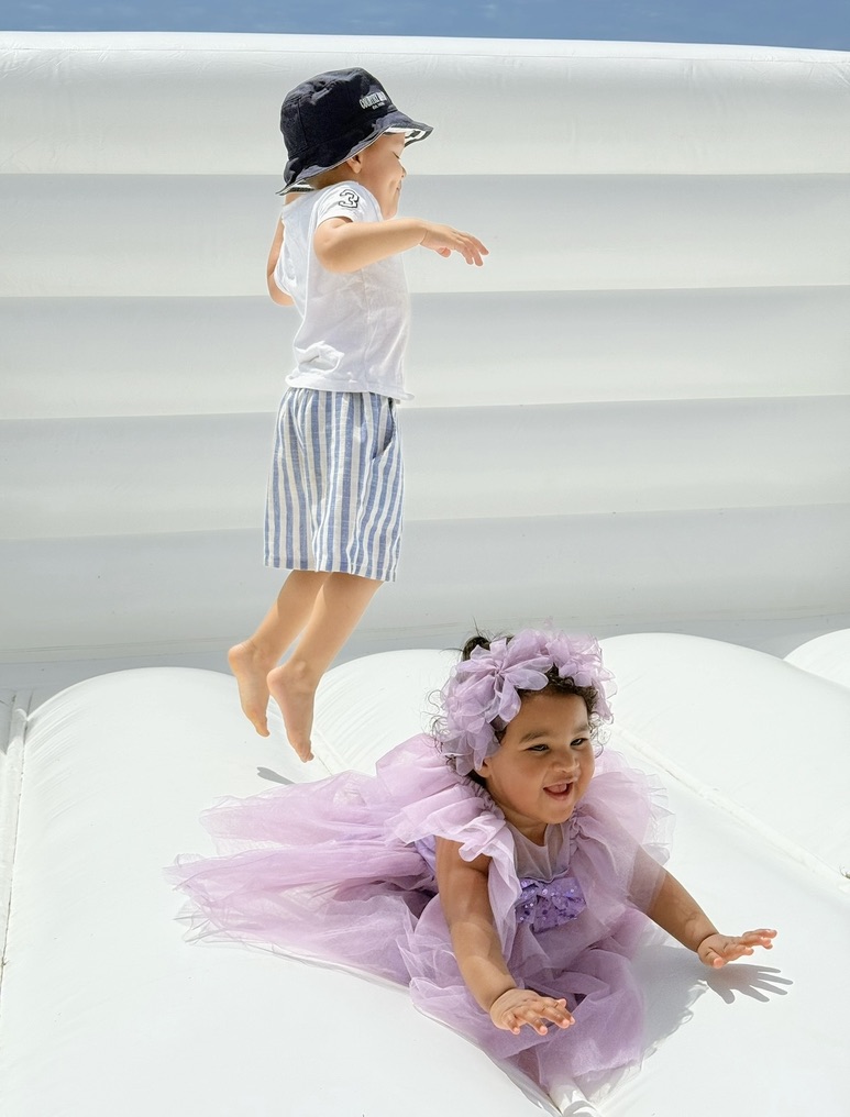 Raaziq and Leyana playing together on a white inflatable